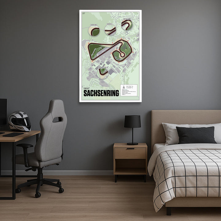 Room interior with a bed, desk, and chair, featuring a map of Circuit Sachsenring on the wall.