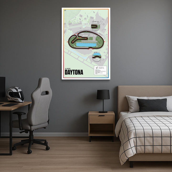 Room interior with a bed, desk, and chair, featuring a framed map of Daytona International Speedway on the wall.