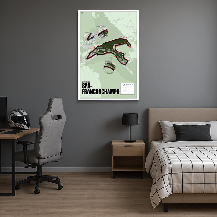 Room interior with a bed, desk, and chair, featuring a hanging artwork of Spa-Francorchamps on the wall.