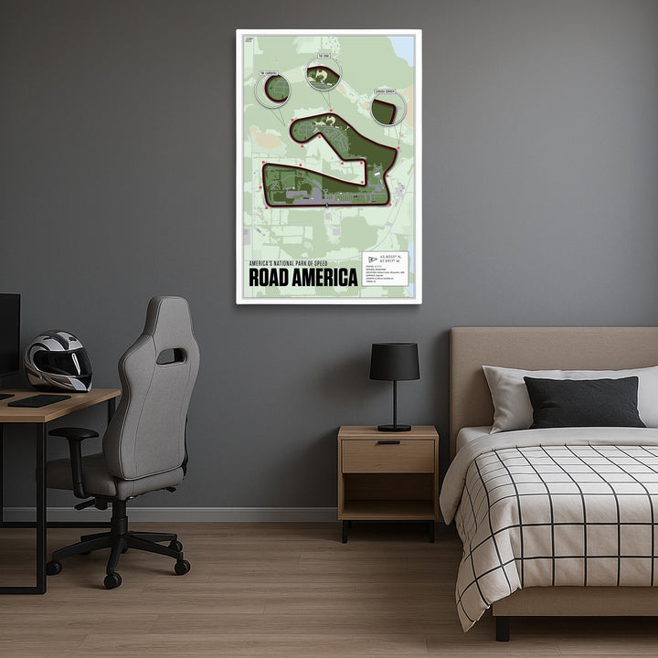 Room interior with a bed, desk, and framed map of Road America on the wall.