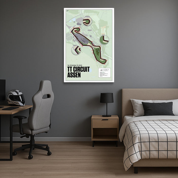 Room interior with a bed, desk, and chair, featuring a framed map of TT Circuit Assen on the wall.